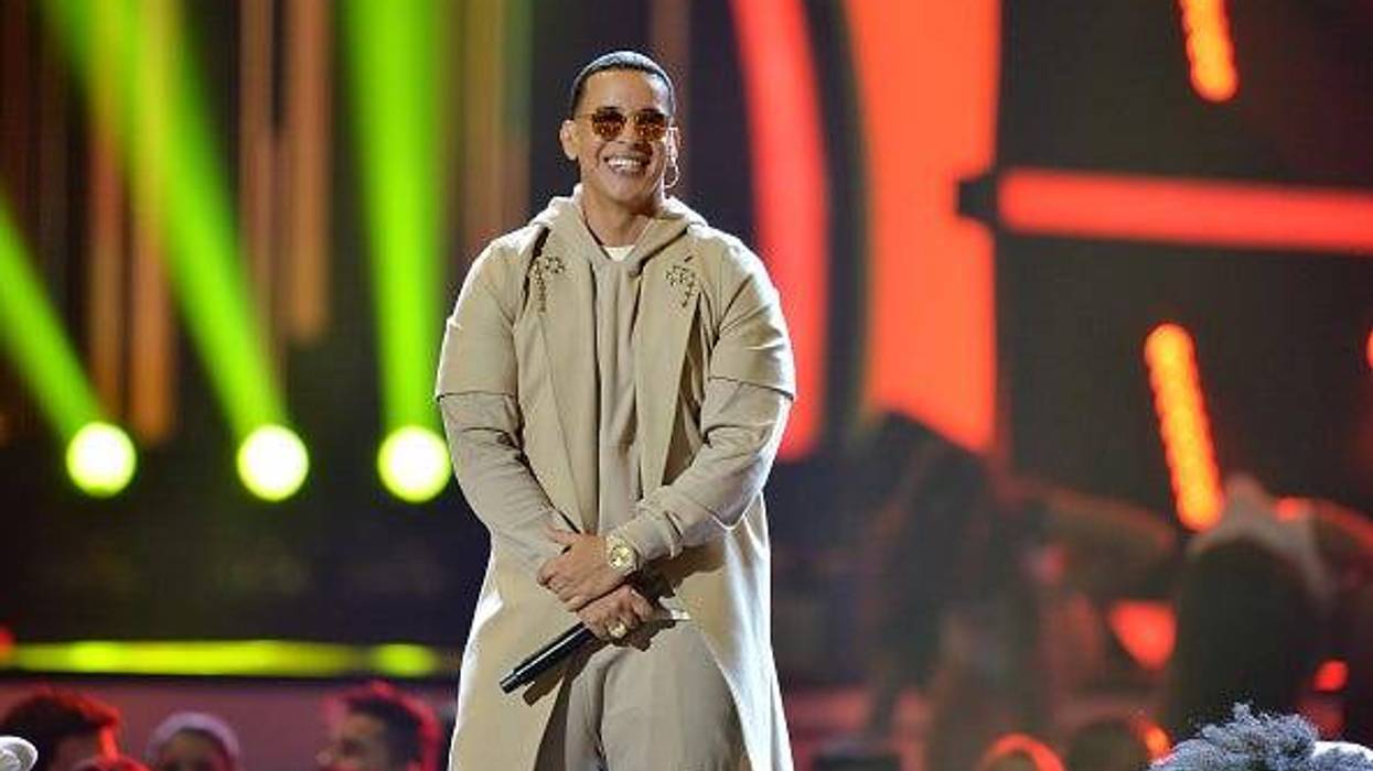 Singer Daddy Yankee on stage wearing sunglasses holding a mic