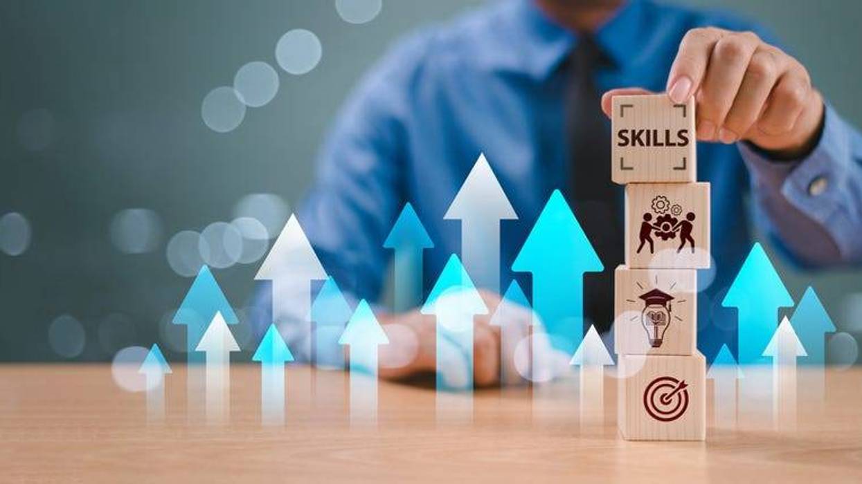 Skill competency development concept. Hand holding wooden cubes representing skills, work, ideas, and success