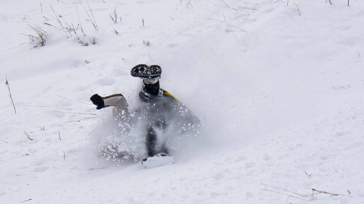 Sledder wipes out going down a hill