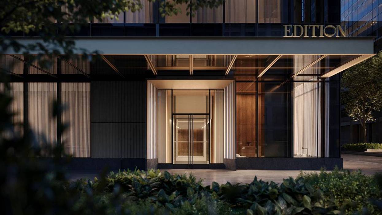 Sleek, modern building entrance at night, glowing invitingly. 'EDITION' sign above, green plants in foreground.