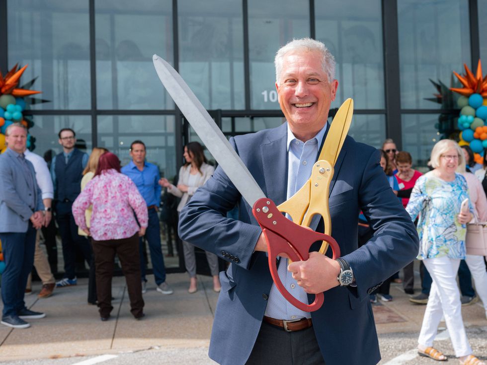 Slumberland Furniture CEO Kenny Larson prepares to cut the ribbon on the company