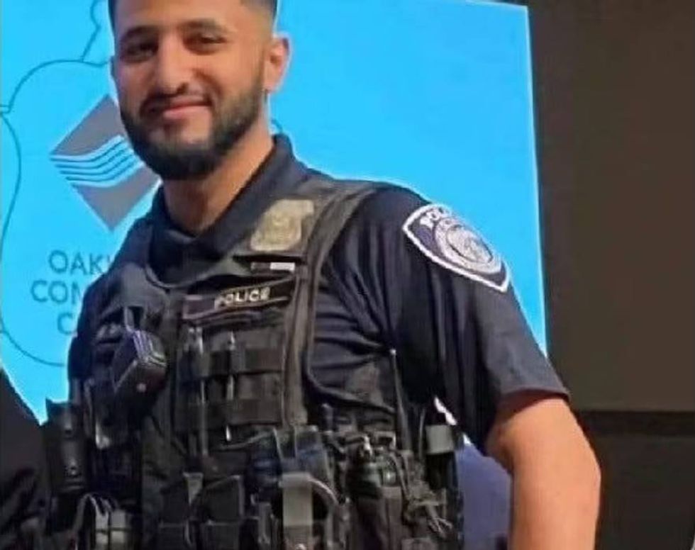 Smiling police officer in uniform and tactical vest.