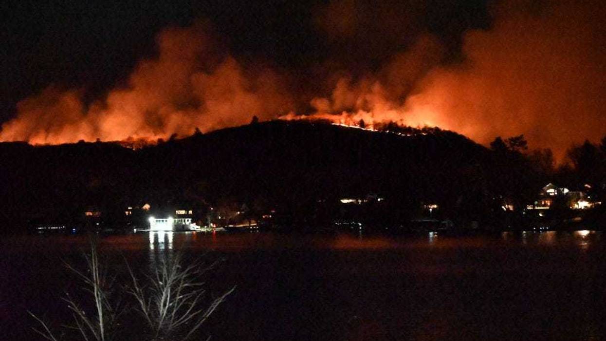 Smoke and flames rise as wildfire burns and spreads on a mountain in West Milford, New Jersey on Nov. 9, 2024. Large flames have overtaken the mountain and more than 2000 acres have burned.