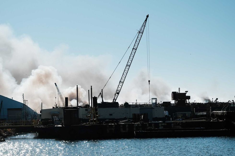 Smoke bellows from a building as firefighters and other emergency personnel work to control a large fire in the Brooklyn neighborhood of Red Hook on December 13, 2022