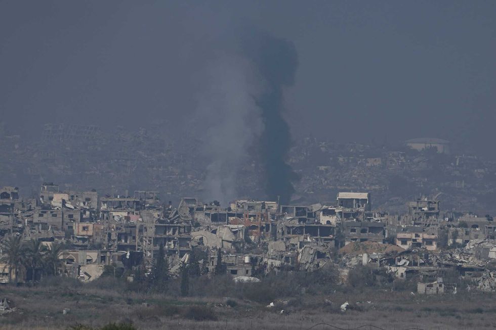 Smoke rises behind destroyed buildings by Israeli bombardments as seen inside the Gaza Strip from southern Israel, Thursday, Jan. 16, 2025