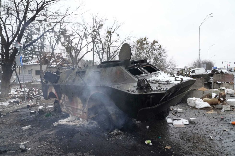 Smoke rises from a damaged armored vehicle at a checkpoint in Brovary, outside Kyiv, Ukraine, Tuesday, March 1, 2022