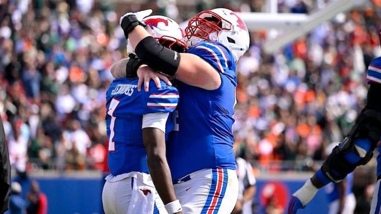 SMU Mustangs quarterback Kevin Jennings (7) and offensive lineman Joshua Bates (64) celebrates after Jennings scores a touchdown against the Miami Hurricanes during the second half at Gerald J. Ford Stadium