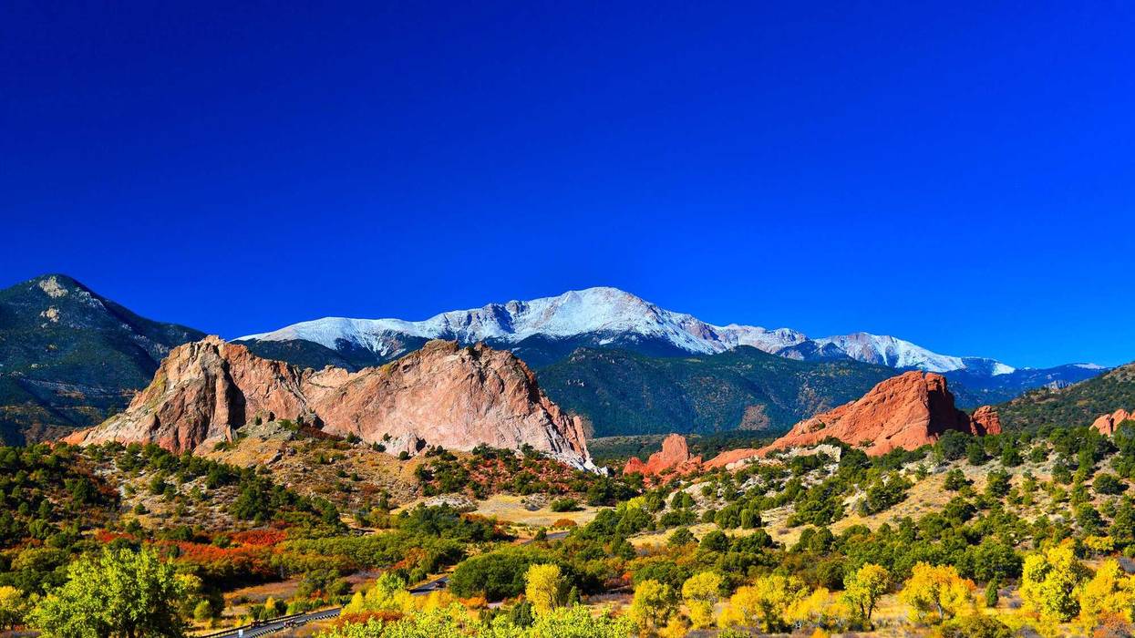 Snow capped Pikes Peak soaring over the Garden of the Gods Park in Colorado Springs, Colorado in a colorful Autumn morning.