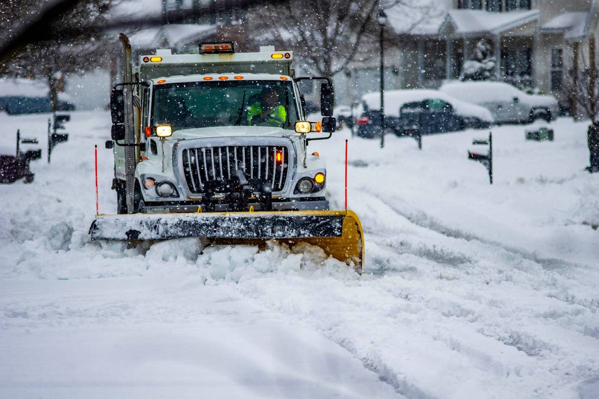 Snow plow clearing snow off of roadway