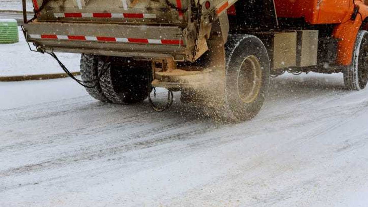 Snow plow salting icy roads.