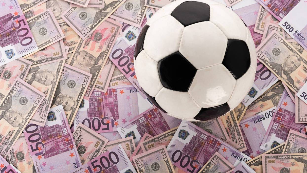 soccer ball on euro and dollar banknotes