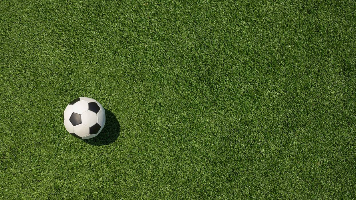 Soccer Ball on Green Grass Field with White Corner