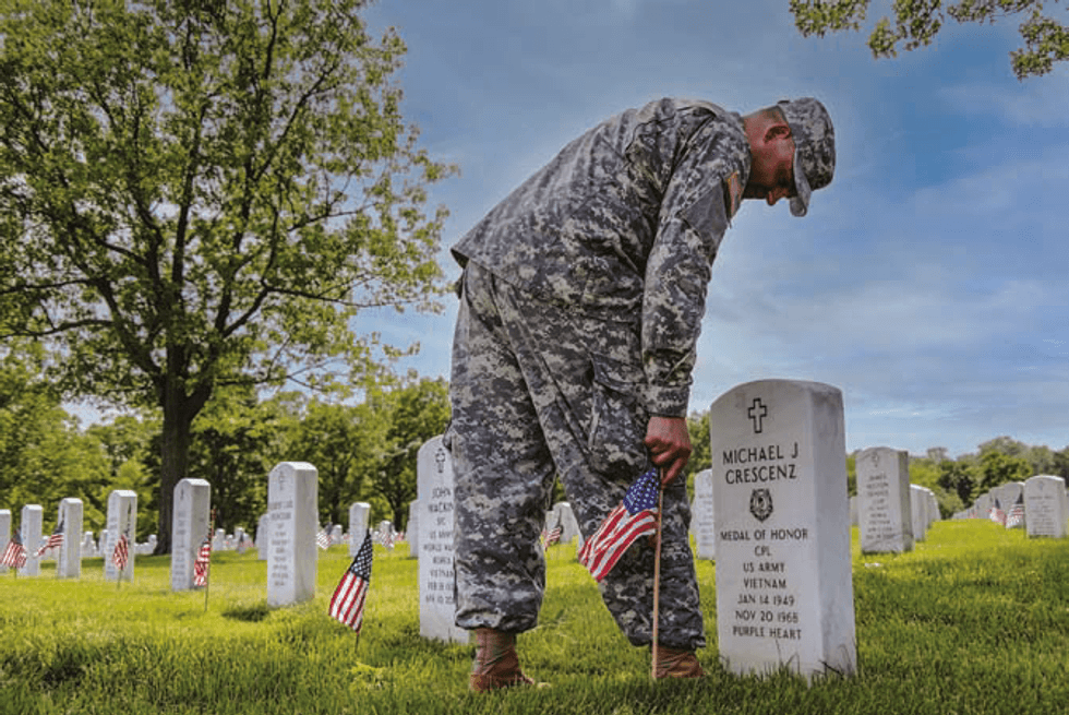Soldier placing flag at Michael