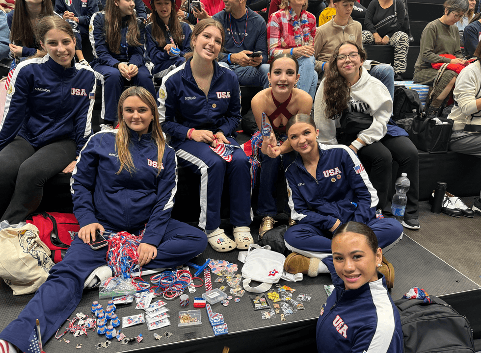 Some of the girls watching the dancers while trading pins and things with kids from other countries.