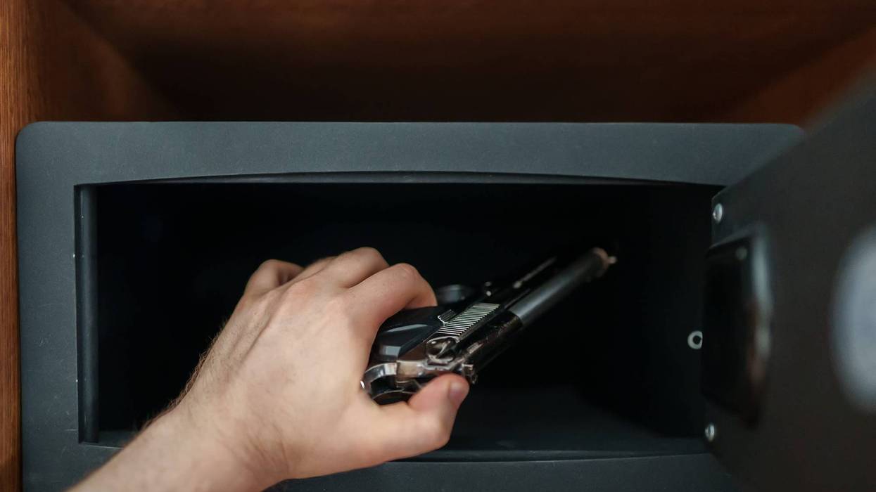 someone places a gun into a gun safe