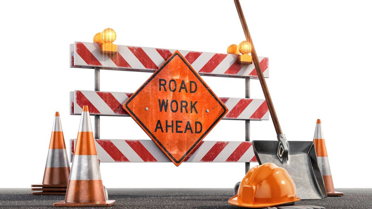 Сonstruction site with a Road Work Ahead sign, traffic cones, hard hat, shovel against a white background.