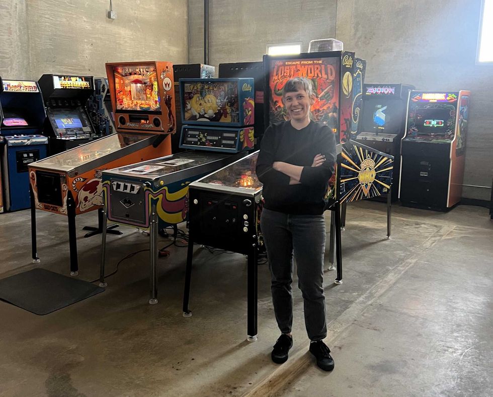 Sopko poses for a photo in front of some of the arcade machines at Upton