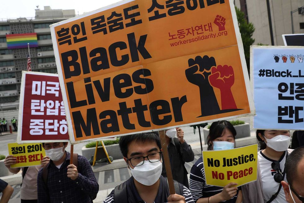 South Korean activists gather to mourn the death of George Floyd and show solidarity with the Black Lives Matter movement near the U.S. embassy on June 05, 2020 in Seoul, South Korea. Activists hold a rally to support the Black Lives Matter movement in the United States and remember George Floyd. The movement has been spreading across the U.S. and around the world following the death of George Floyd, a black American at the hands of a white police officer. (Photo by Chung Sung-Jun/Getty Images)