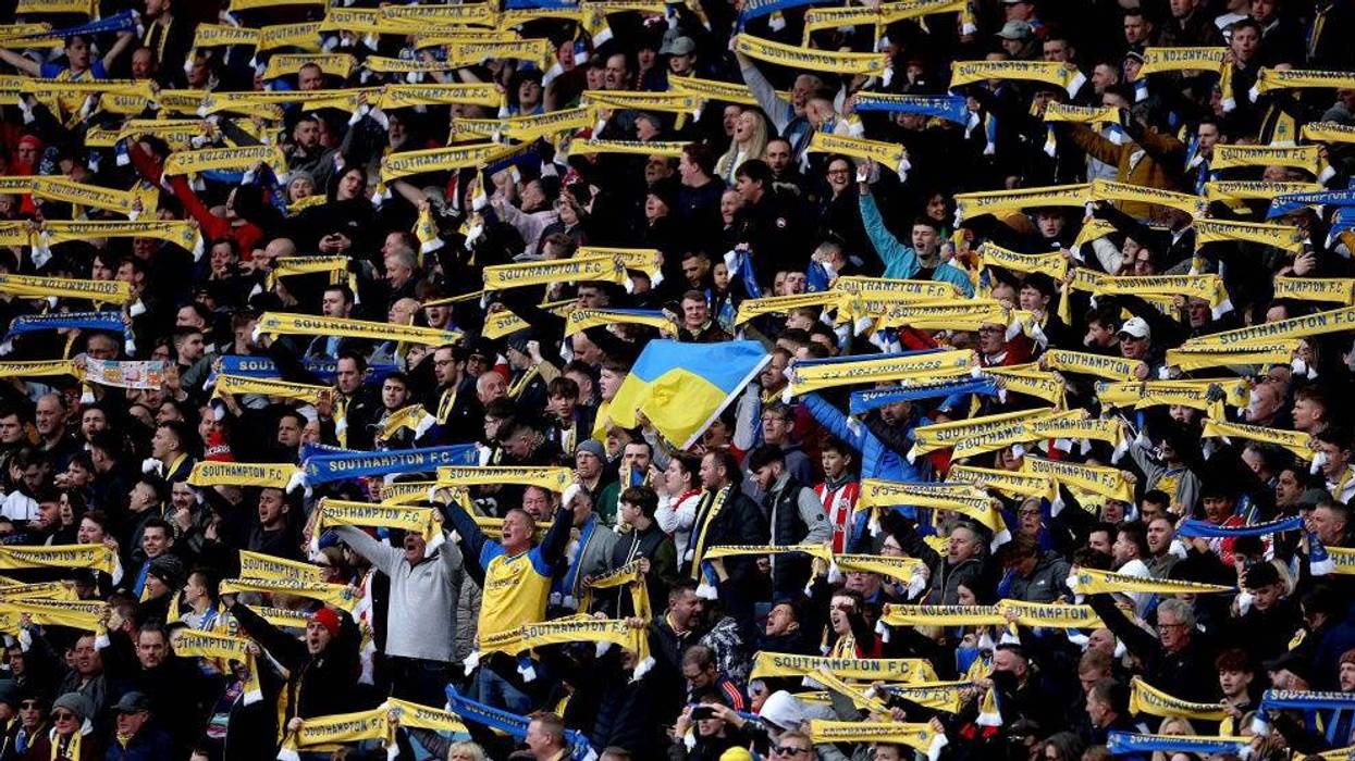 Southampton fans hold banners and scarves with the Ukrainian flag to indicate peace and sympathy with Ukraine prior to the Premier League match between Aston Villa and Southampton at Villa Park on March 05, 2022 in Birmingham, England.
