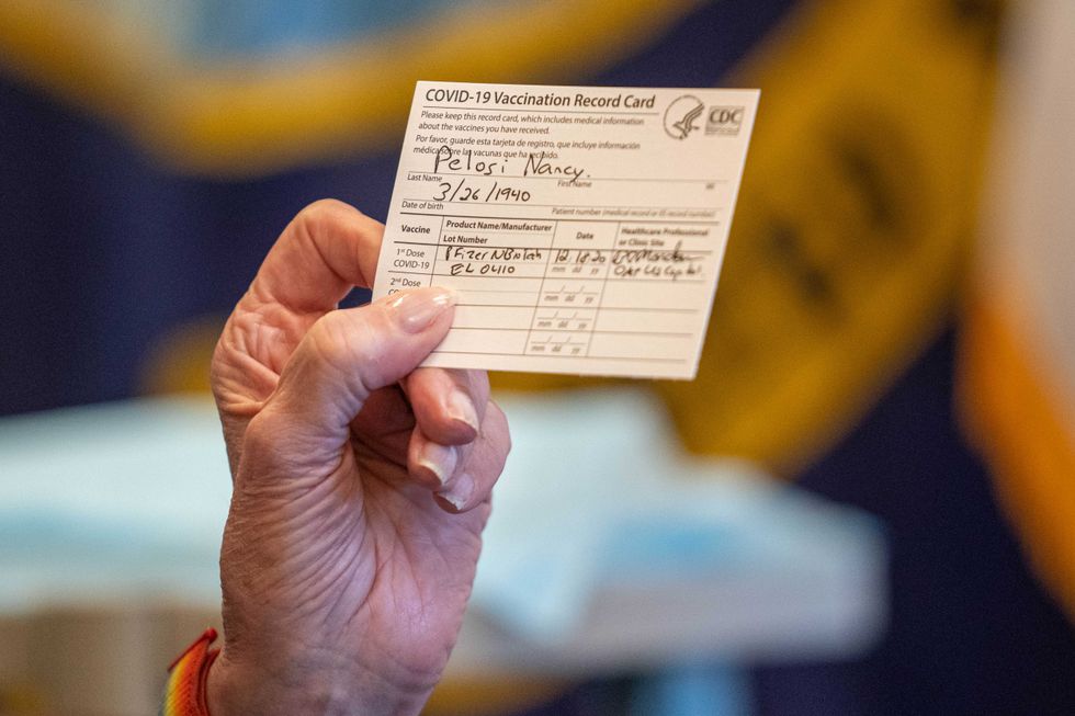 Speaker of the House Nancy Pelosi (D-CA) holds up a Vaccination Record Card after receiving a COVID-19 vaccination shot by Dr. Brian Monahan, attending physician of the Congress of the United States, in her office on Capitol Hill on December 18, 2020 in Washington, DC.