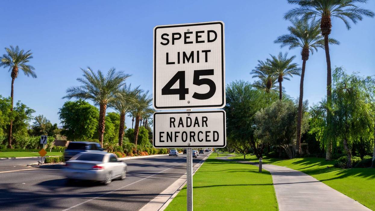 Speed Limit 45 Radar Enforced road sign with passing cars on a California street.