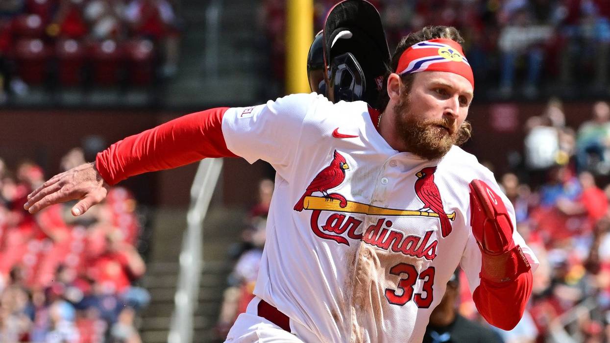 St. Louis Cardinals infielder Brendan Donovan (33) loses his batting helmet as he digs for third base against the Philadelphia Phillies at Busch Stadium.