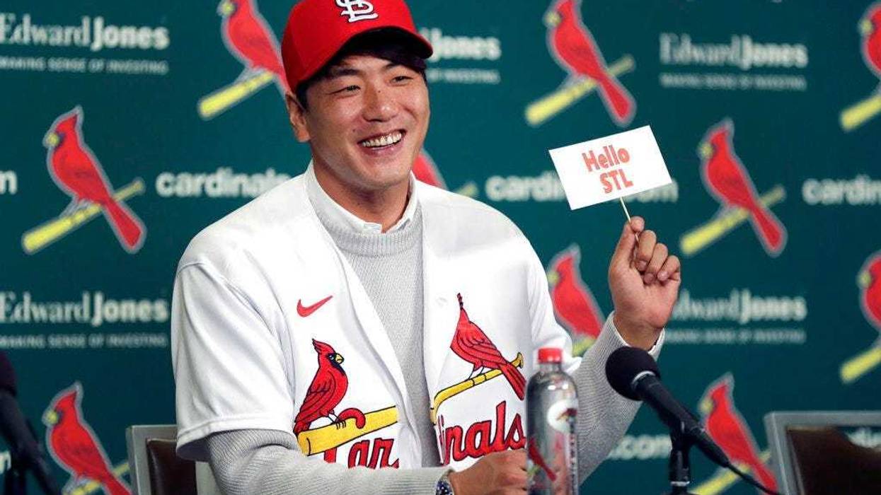 St. Louis Cardinals pitcher Kwang-Hyun Kim smiles as he holds up a sign during a news conference Tuesday, Dec. 17, 2019, in St. Louis. The Cardinals have signed the Korean left-hander to a two-year contract.