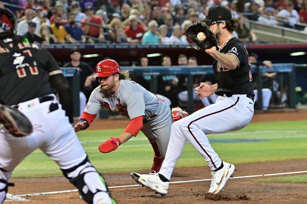 St. Louis Cardinals second baseman Brendan Donovan (33) scores as Arizona Diamondbacks starting pitcher Zac Gallen (23) and catcher Jose Herrera (11) defend in the third inning at Chase Field.