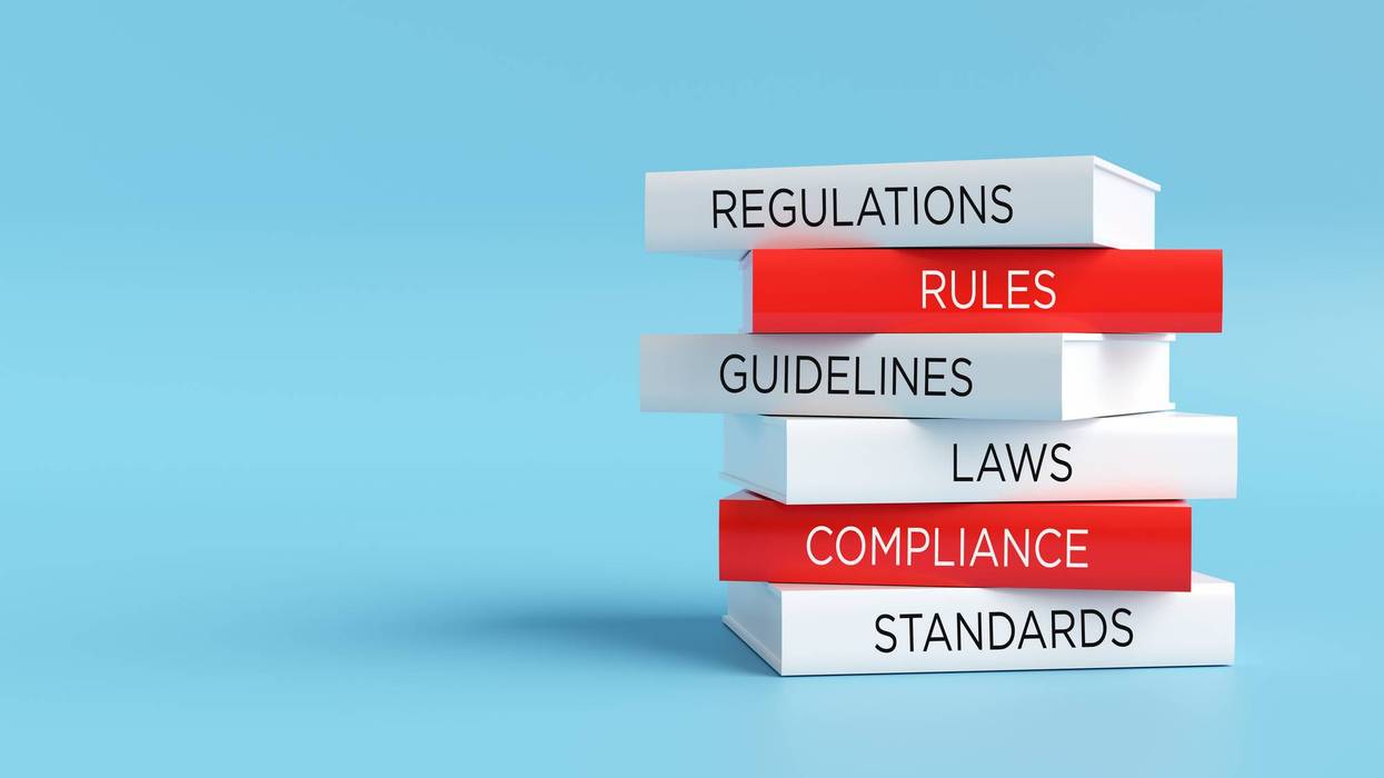 Stack of books representing regulatory compliance and legal standards