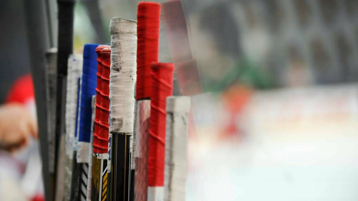 Stack of hockey sticks at a rink, showing the grip tape at the top