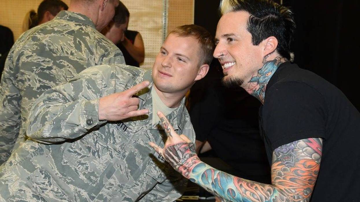 Staff Sgt. Michael Gigliotti poses for a photo with drummer Jeremy Spencer of Five Finger Death Punch at Nellis Air Force Base