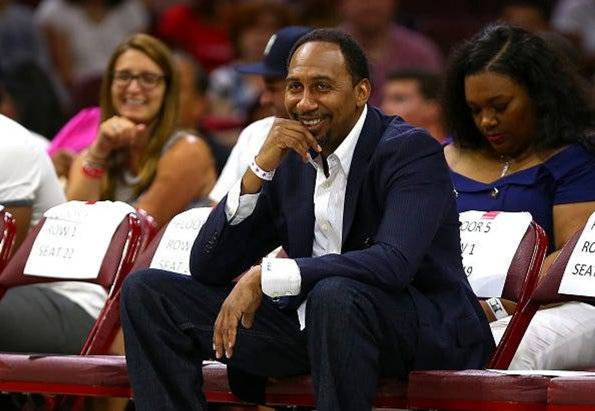 Stephen A. Smith watches a basketball game courtside.