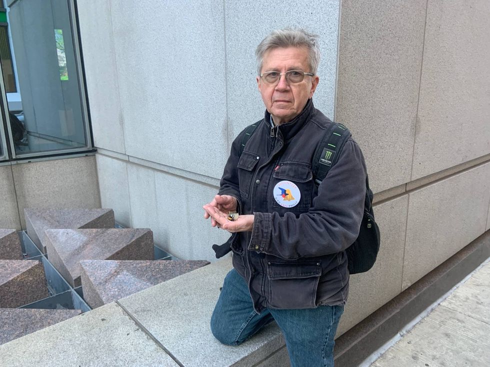 Stephen Maciejewski, a retired social worker and Audubon Society volunteer, holds a dead golden-crowned kinglet.