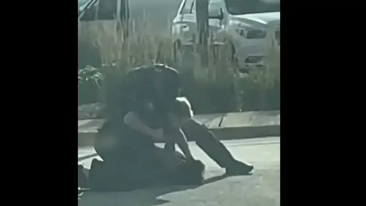Still showing two officers pin a teenager to the ground