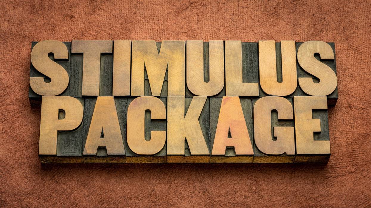 stimulus package word abstract in vintage letterpress wood type against textured handmade paper