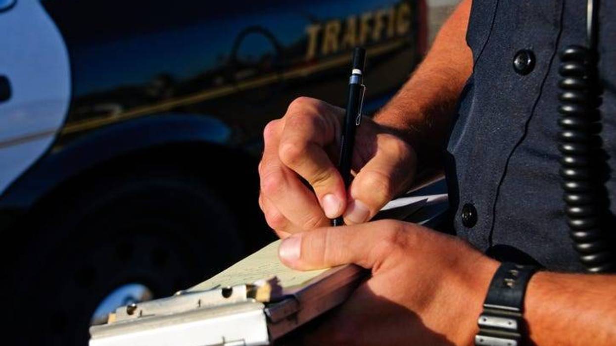 Stock image of a police officer writing a ticket.