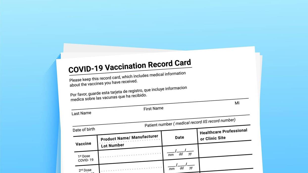Stock image of paper COVID-19 vaccine card.