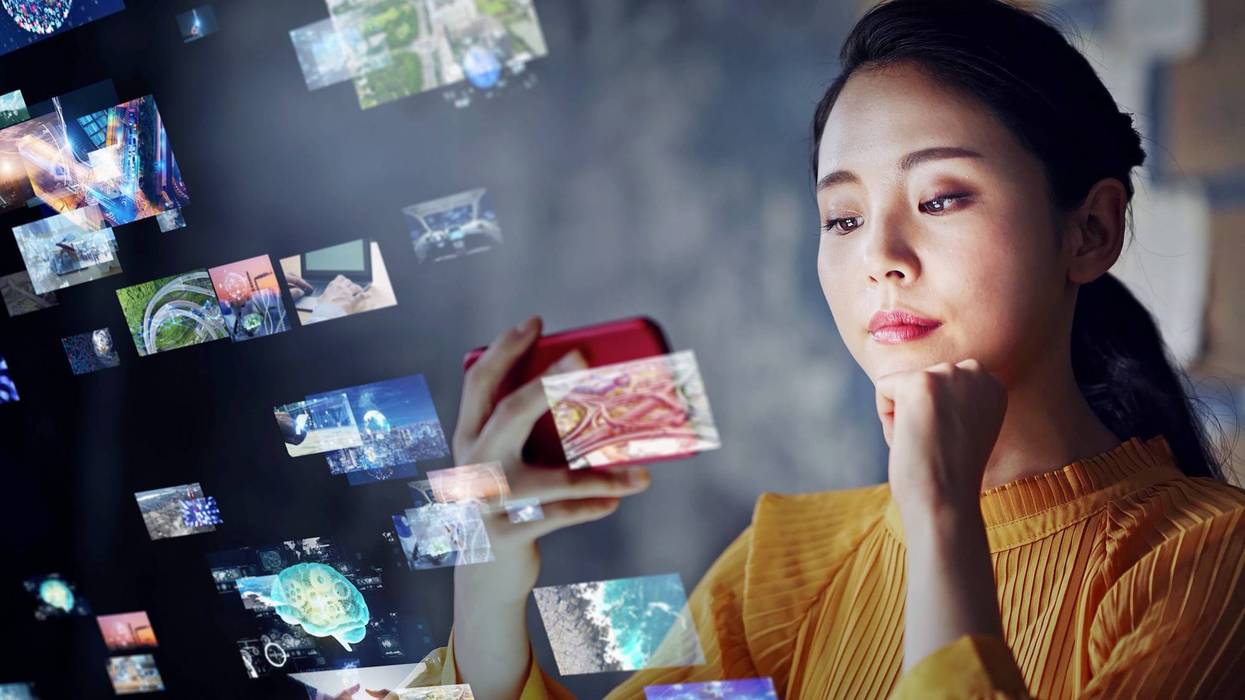 stock image of woman on her phone with digital images floating in the space around her