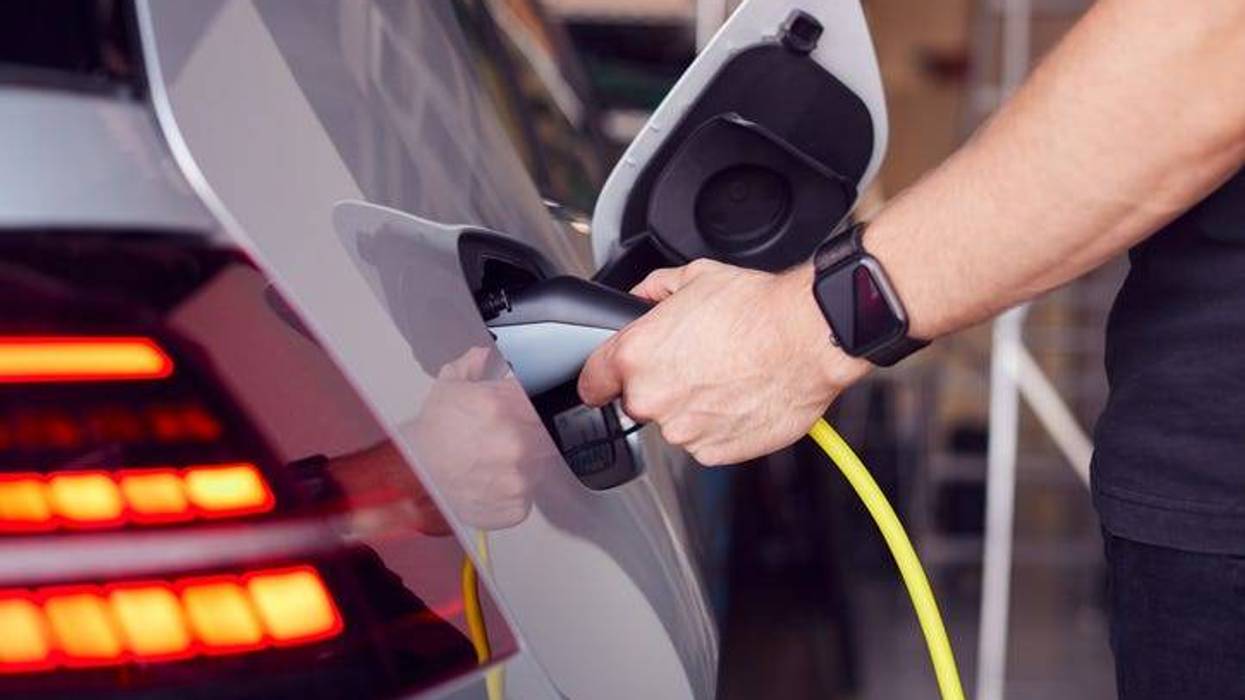 Stock photo of a man using a home charging station.