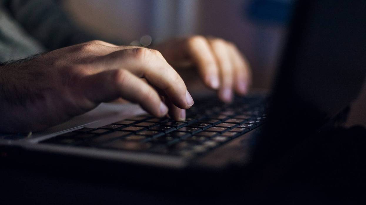 Stock photo of man using laptop in the dark