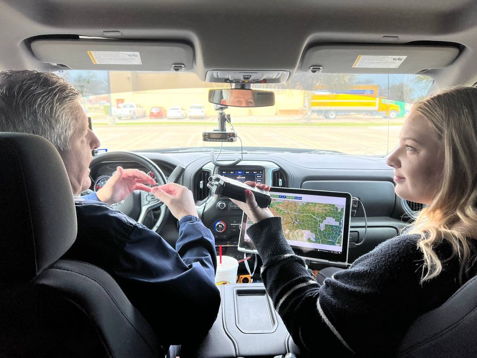 Storm chaser Joe Bajza, right, shows Baylee Friday, left, the technology he uses when he