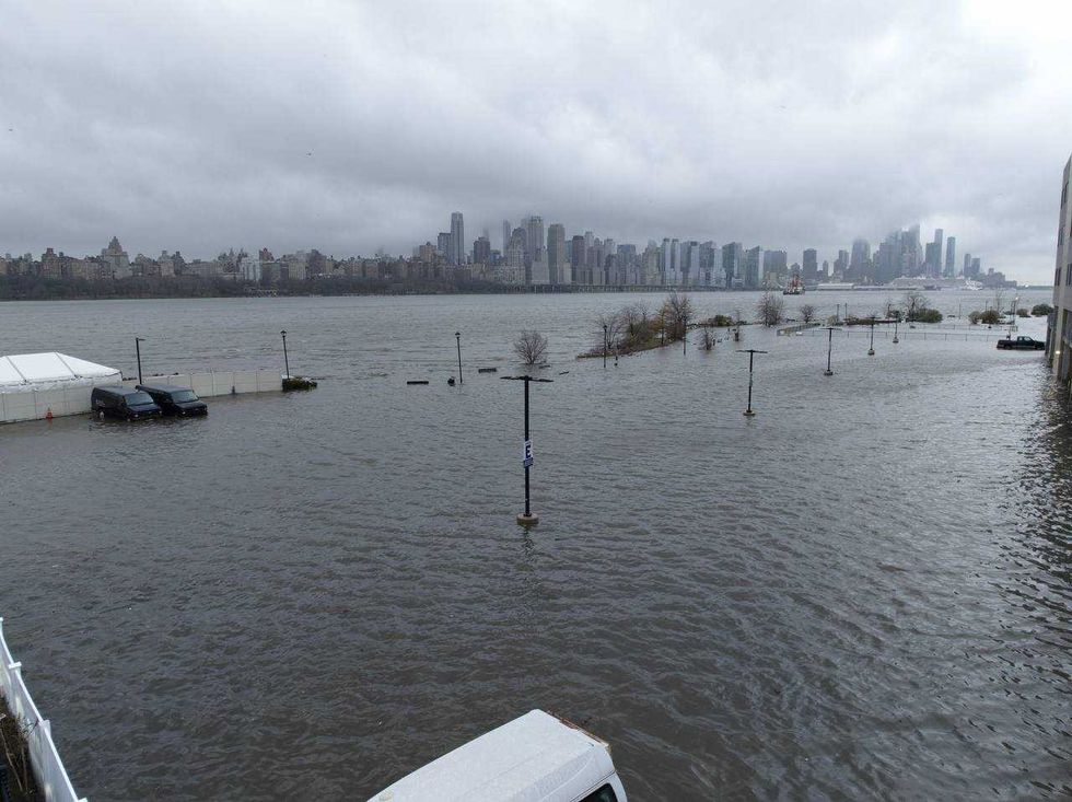 Storm clouds are seen as the Hudson River spills over a river wall in front of the skyline of lower Manhattan in New York City during an severe flooding due to the winter storm in New Jersey on Dec. 23, 2022