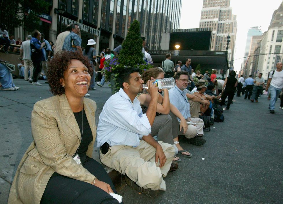 Stranded travelers at Penn Station wait on the street during the massive blackout.