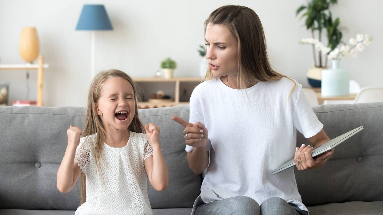 Strict mom scolding ill-behaved daughter screaming loud at home