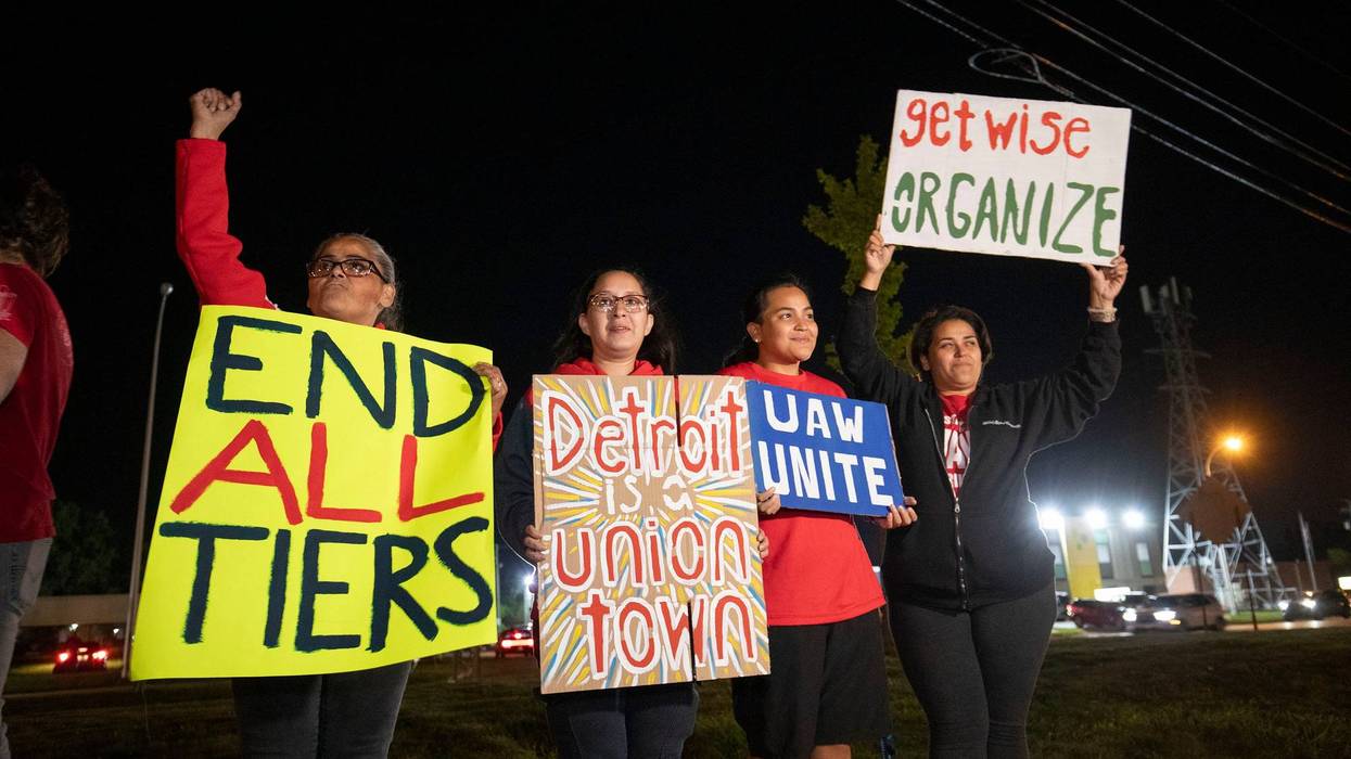 Striking UAW workers hold signs in Metro Detroit