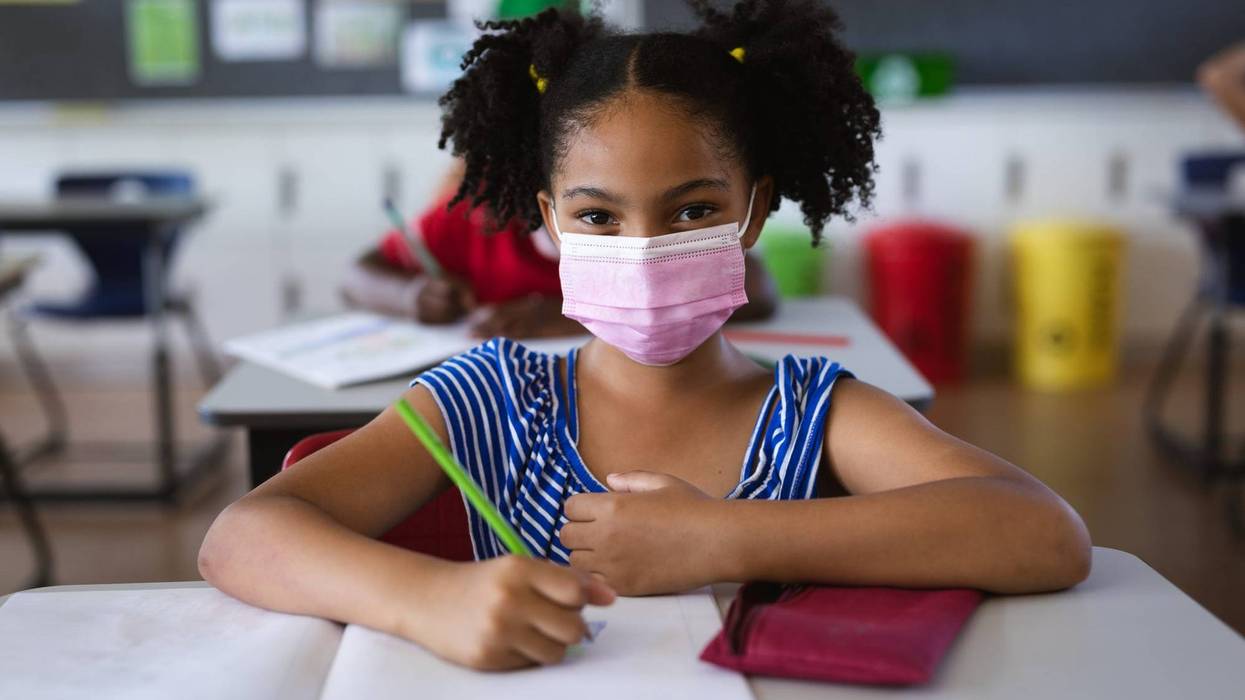 student at desk wearing face mask