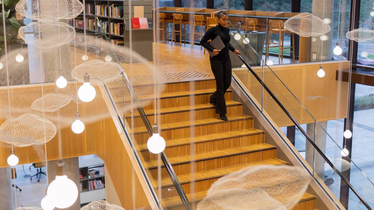 Student descending staircase in library