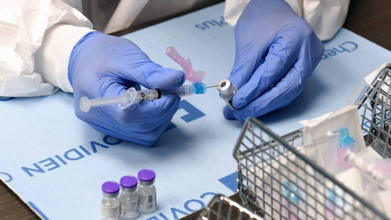 Student pharmacist Wilbur Quimba dilutes vials of the Pfizer-BioNTech COVID-19 vaccine at University Medical Center of Southern Nevada on December 16, 2020, in Las Vegas, Nevada