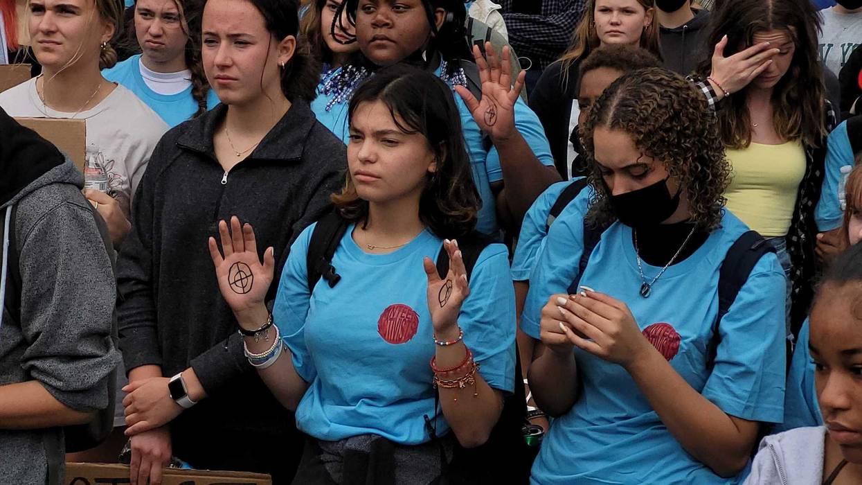 Students affected by gun violence raise hands during a May 2022 rally