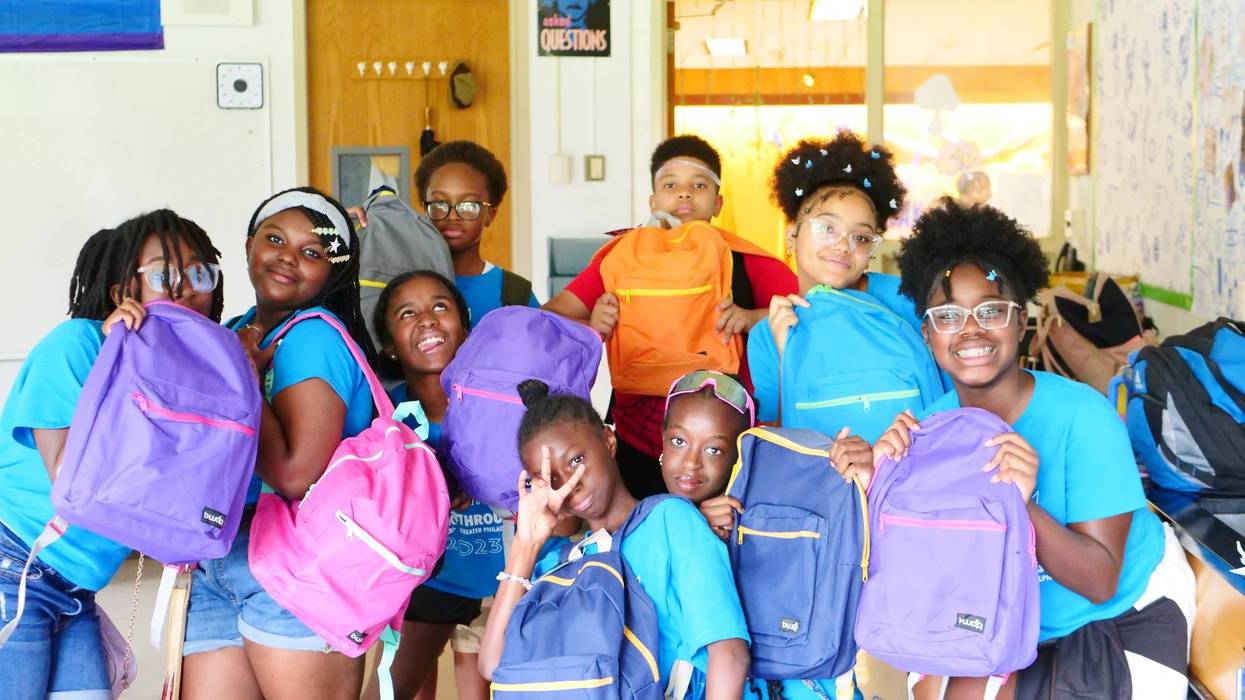 Students pose for a picture with their new backpacks ahead of the first day of school.